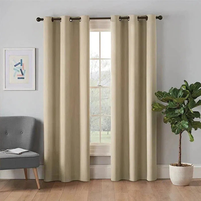 Rideaux élégants de couleur beige suspendus devant une fenêtre, ajoutant une touche de sophistication à un intérieur moderne. Ils sont accompagnés d'un fauteuil gris, d'une plante décorative et d'un tableau abstrait, créant une atmosphère chaleureuse et contemporaine. Idéal pour sublimer votre salon ou votre chambre avec style et élégance.