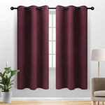 Paire de rideaux occultants à œillets, couleur aubergine, suspendus devant une fenêtre dans un salon moderne. Parfaits pour bloquer la lumière et offrir une intimité optimale. Accessoire élégant pour embellir votre intérieur.