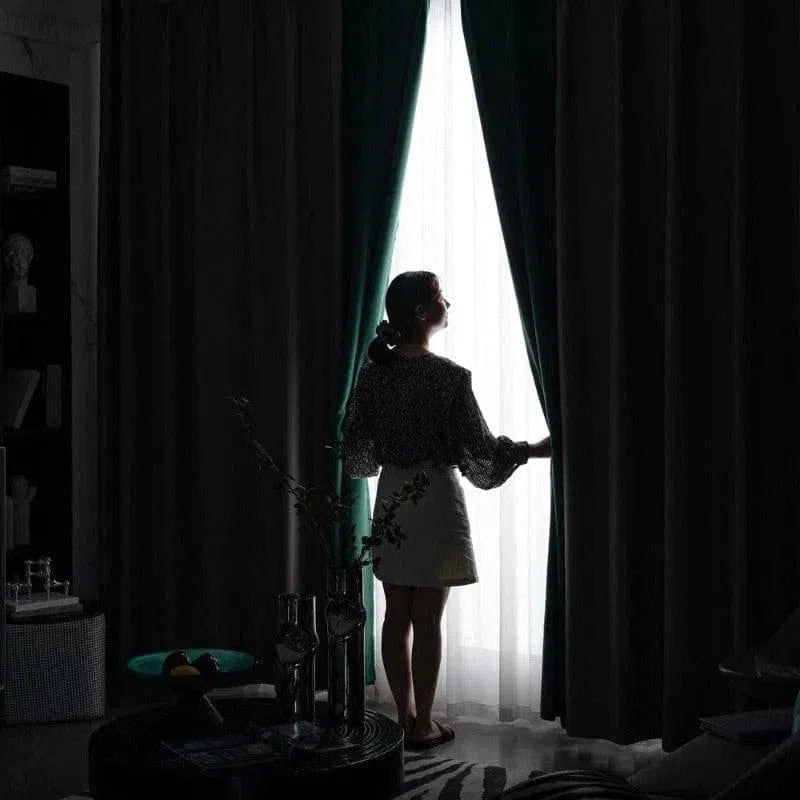 Femme ouvrant des rideaux sombres dans un salon élégant, permettant à la lumière naturelle d'entrer. Ambiance harmonieuse grâce à la décoration intérieure moderne. Atmosphère accueillante et chic, idéale pour profiter de moments de détente à la maison.