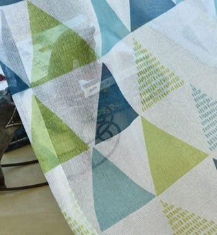 Image d'un tissu aux motifs géométriques colorés en vert et bleu, idéal pour apporter une touche moderne à votre intérieur. Design contemporain parfait pour décoration de maison, rideaux ou accessoires textiles tendance.