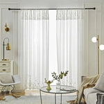 Rideaux semi-transparents élégants suspendus dans un salon moderne avec décoration lumineuse, comprenant un canapé confortable, une table basse avec vase et un éclairage contemporain, offrant une ambiance raffinée et accueillante.