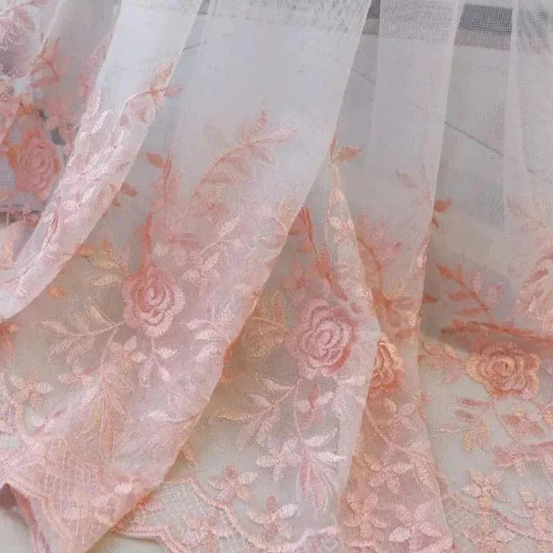 Voile délicat avec broderies florales roses, parfait pour ajouter une touche d'élégance et de charme à votre décoration intérieure. Idéal pour des rideaux ou des draperies sophistiquées, ce tissu au design raffiné s'intègre harmonieusement dans tout style de pièce.