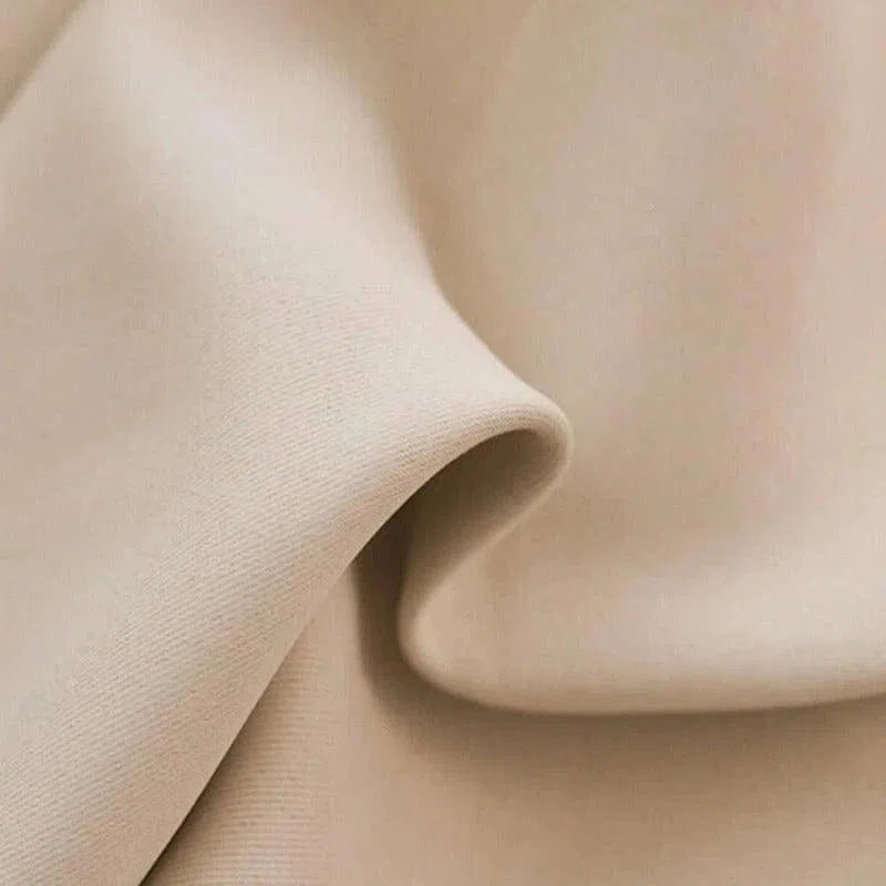 Image présentant un tissu beige avec une texture douce et élégante, idéal pour la décoration intérieure ou la confection de vêtements. Ce tissu met en valeur des finitions raffinées et un design moderne, parfait pour ajouter une touche sophistiquée à n'importe quel projet créatif.
