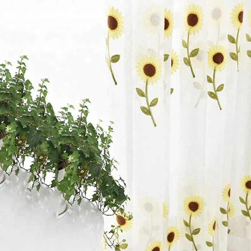 Rideau décoratif avec motif de tournesols, idéal pour ajouter une touche lumineuse et naturelle à votre intérieur. Parfait pour les salons ou chambres, ce rideau rehausse votre décoration avec élégance. Accompagné de feuillage vert, il crée une ambiance fraîche et accueillante.