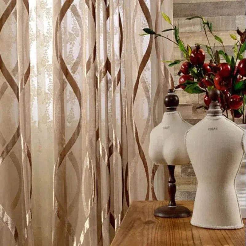 Rideaux élégants avec motifs géométriques dans un intérieur moderne, accompagnés de bustes de couture sur une table en bois, ajoutant une touche décorative sophistiquée et artistique à la pièce lumineuse.