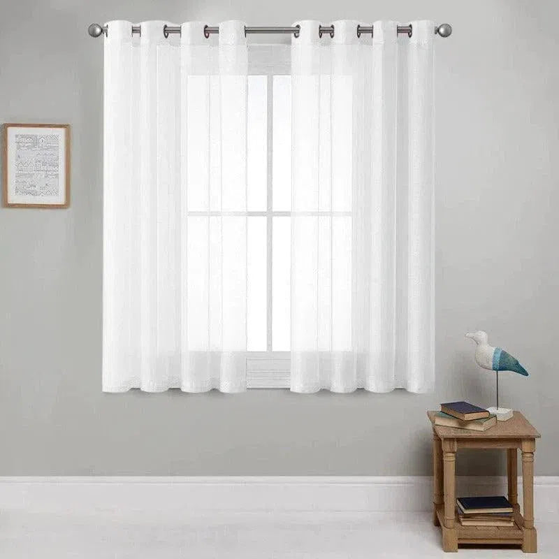 Rideau blanc élégant suspendu à une tringle, parfait pour illuminer un salon moderne. Décoration intérieure avec une table en bois claire, livres empilés et sculpture d'oiseau, encadrée par des murs gris doux. Accessoire idéal pour ajouter une touche de sophistication et de luminosité à une pièce.