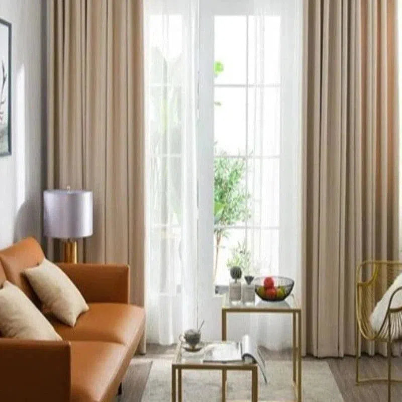 Rideau en tissu beige élégant dans un salon moderne, apportant une touche chaleureuse et sophistiquée à l'intérieur. Ce rideau de qualité supérieure est idéal pour habiller les grandes baies vitrées, offrant à la fois intimité et style. Parfait pour une décoration contemporaine.