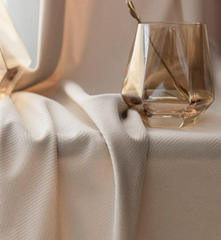 Verre d'eau élégant avec des reflets ambrés sur une table. Décoration intérieure raffinée pour un espace moderne et sophistiqué. Ambiance chaleureuse et luxueuse dans un cadre lumineux. Idéal pour un intérieur stylé et contemporain.