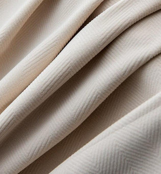 Drapé élégant de tissu beige avec motif subtil en chevrons, idéal pour la décoration intérieure et la confection de vêtements sophistiqués. Design raffiné et moderne, parfait pour ajouter une touche de charme à tout espace.