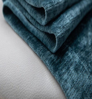Tissu bleu texturé plié soigneusement sur une surface claire, idéal pour la décoration intérieure et l'ameublement. Accessoire tendance pour sublimer votre espace de vie avec élégance et modernité.