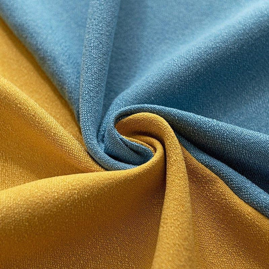 Image d'un tissu plissé dans des tons de bleu et de jaune, illustrant le contraste vibrant entre les couleurs. Cette composition élégante met en avant la texture et le motif, idéale pour la décoration intérieure ou la confection d'articles de mode uniques. Parfaite pour les projets créatifs qui nécessitent une touche de couleur et de sophistication.