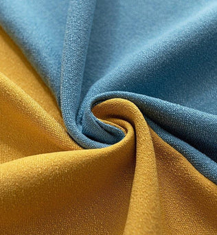 Image d'un tissu plissé dans des tons de bleu et de jaune, illustrant le contraste vibrant entre les couleurs. Cette composition élégante met en avant la texture et le motif, idéale pour la décoration intérieure ou la confection d'articles de mode uniques. Parfaite pour les projets créatifs qui nécessitent une touche de couleur et de sophistication.