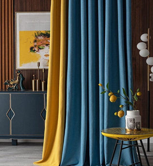 Rideaux élégants dans une pièce moderne avec un contraste de couleurs bleu et jaune, créant une ambiance contemporaine. Décorations artistiques sur un buffet chic et tableau coloré en arrière-plan. Table d'appoint moderne avec vase et citronnier, ajoutant une touche naturelle à l'ensemble. Design intérieur harmonieux et sophistiqué.