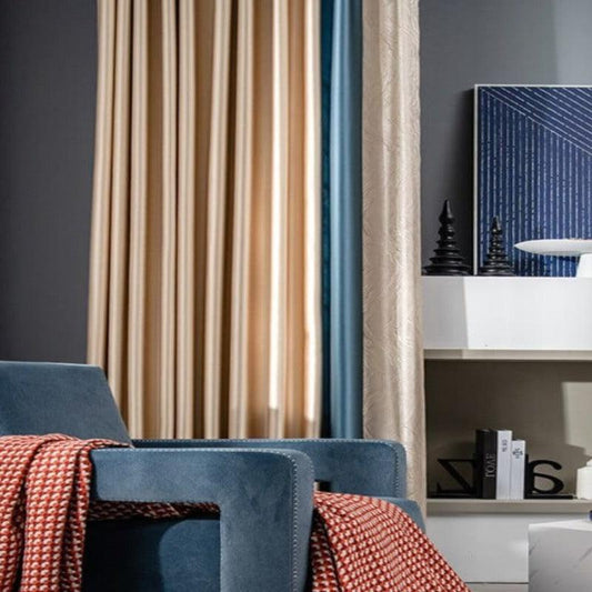 Fauteuil bleu élégant avec plaid rouge en maille dans un salon moderne. Rideaux en arrière-plan avec décorations minimalistes sur étagère. Ambiance contemporaine et chaleureuse. Idéal pour un intérieur décoré avec style et confort.