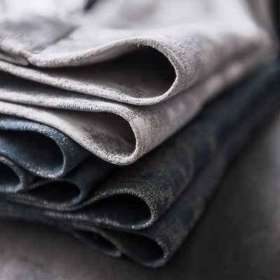 Ensemble de tissus pliés aux nuances de gris et bleu, parfait pour la confection de vêtements élégants ou d'ameublement moderne, offrant un design raffiné et contemporain pour vos projets créatifs.