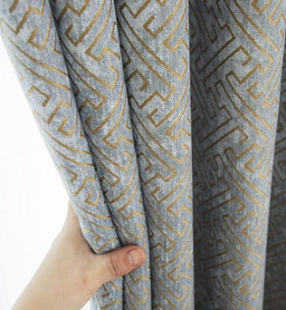Rideau à motif géométrique gris et doré, parfait pour une décoration intérieure moderne et élégante. Accessoire idéal pour habiller vos fenêtres avec style et sophistication.