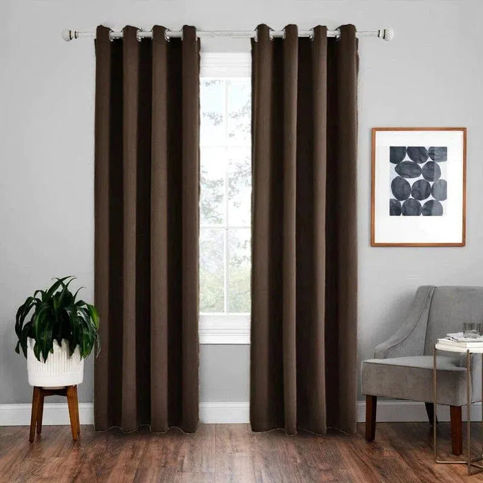 Rideau élégant marron suspendu sur une tringle, apportant une touche moderne à un salon. Le rideau encadre parfaitement une grande fenêtre, offrant intimité et style. À côté, un fauteuil gris et une plante verte en pot ajoutent une ambiance chaleureuse. Idéal pour tout intérieur contemporain.