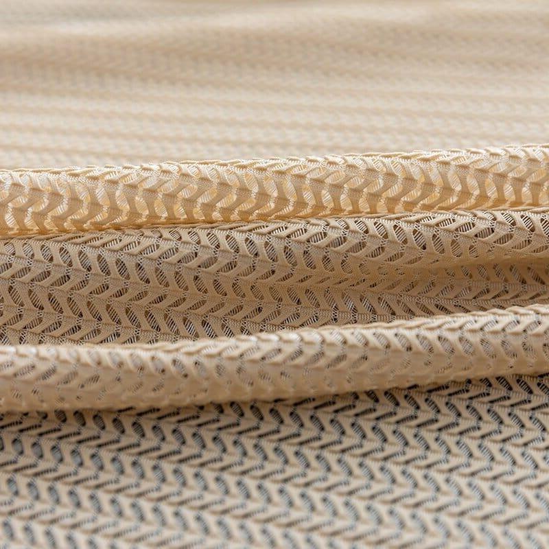Tissu beige à motif géométrique chevron offrant un design élégant pour la décoration intérieure ou la confection de vêtements, idéal pour un style moderne et raffiné.
