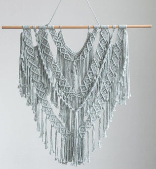 Décoration murale en macramé bohème chic avec motifs géométriques, idéale pour ajouter une touche d'élégance ethnique à votre intérieur. Cette pièce artisanale authentique capte l'attention par ses détails raffinés et ses franges harmonieuses. Parfait pour le salon ou une chambre, offrant une ambiance cosy et tendance.