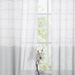 Rideaux blancs transparents laissant entrer la lumière naturelle, parfaits pour une décoration intérieure élégante et lumineuse, idéal pour créer une ambiance paisible et accueillante dans votre salon ou chambre à coucher.
