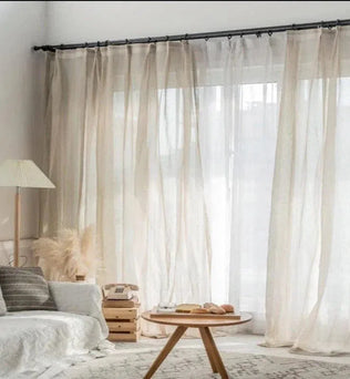Rideaux transparents élégants pour un salon lumineux. Décoration intérieure moderne avec un canapé confortable, une table basse en bois et un lampadaire design. Ambiance apaisante et naturelle, idéale pour créer un espace accueillant et chaleureux. Parfaits pour filtrer la lumière tout en ajoutant une touche de style à votre maison.