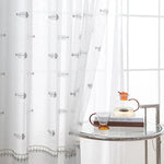 Voilage translucide avec motifs de poisson, parfait pour ajouter une touche marine subtile à votre décoration d'intérieur. Idéal pour illuminer la pièce tout en préservant une ambiance cosy et élégante. Accessoire déco chic pour salon ou chambre, avec une table moderne et une carafe design.