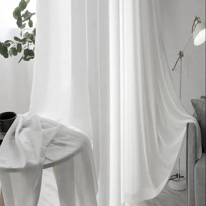 Rideaux blancs élégants pour salon moderne, parfaits pour laisser entrer la lumière naturelle tout en préservant l'intimité. Design minimaliste s'adaptant à tous types d'intérieurs contemporains. Atmosphère lumineuse et apaisante assurée.