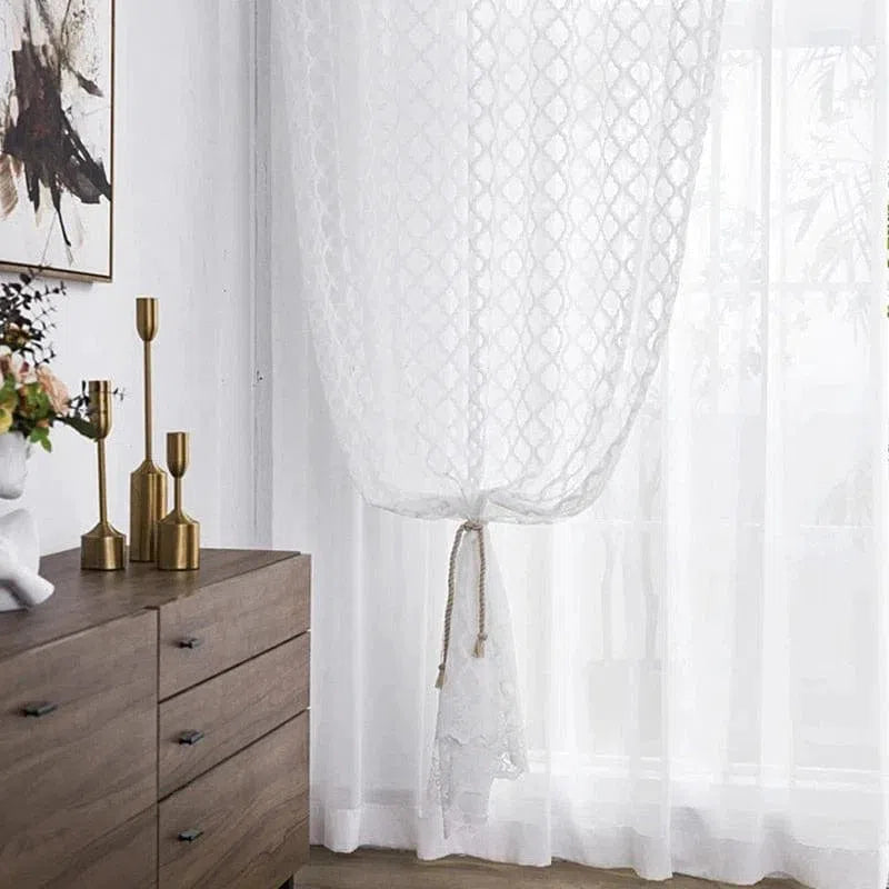 Rideau blanc élégant dans un salon moderne avec un motif géométrique subtil. Décoration intérieure raffinée comprenant une commode en bois et des bougeoirs dorés. Ambiance lumineuse et accueillante idéale pour créer une atmosphère cosy et chic.