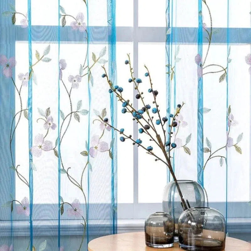 Rideaux décoratifs bleus ornés de motifs floraux, parfaits pour ajouter une touche élégante à votre salon ou chambre. Élément de design contemporain, ces rideaux laissent passer la lumière tout en préservant votre intimité. Idéals pour un intérieur moderne et raffiné. Accessoirisés avec des vases élégants pour une décoration harmonieuse.