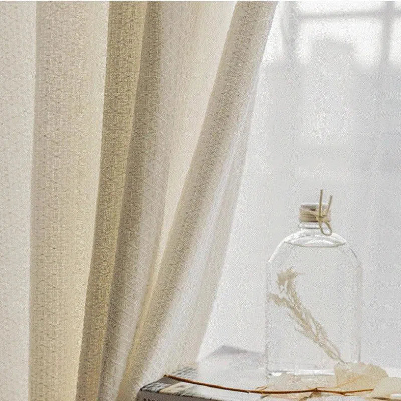 Rideau beige élégant pour intérieur moderne, offrant une ambiance lumineuse et apaisante, idéal pour le salon ou la chambre. Accessoire décoratif épuré avec une bouteille en verre décorative posée sur une table en bois. Parfait pour un style minimaliste et chaleureux.