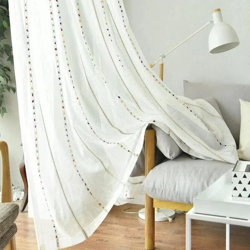 Rideau élégant avec motifs brodés, idéal pour un salon moderne et lumineux. Sa teinte claire s'adapte parfaitement à une décoration épurée, permettant de filtrer délicatement la lumière du jour. Parfait pour ajouter une touche de sophistication et de chaleur à votre espace de vie.