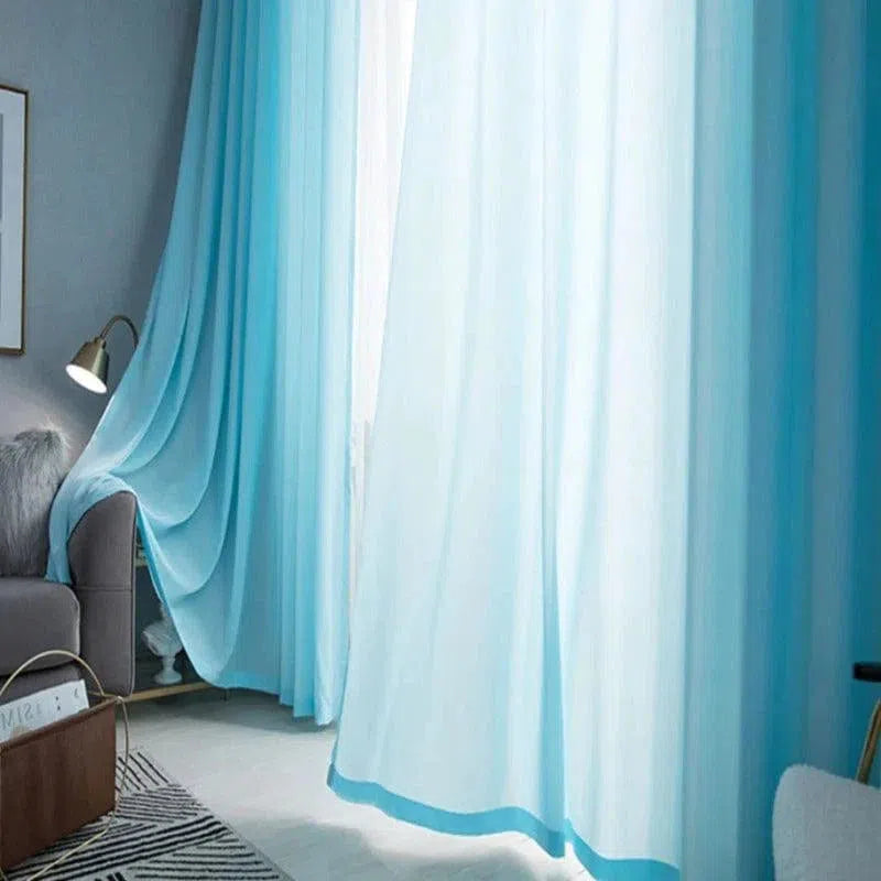 Rideaux bleu clair suspendus dans un salon moderne avec lumière douce filtrée, créant une ambiance apaisante et élégante. Décoration intérieure avec tons neutres et accents de couleur pour une atmosphère harmonieuse et contemporaine.