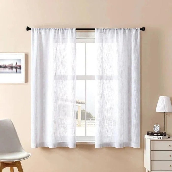 Voilage blanc élégant pour salon, installée sur une tringle noire. Décoration intérieure moderne avec chaise design, lampe de chevet et tableau encadré sur mur beige. Idéal pour filtrer la lumière naturelle tout en préservant l'intimité de votre espace de vie.