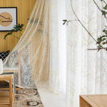 Voilage élégant avec motif végétal dans un salon moderne lumineux, ajoutant une touche de raffinement et d'intimité à la décoration intérieure. Idéal pour créer une ambiance chaleureuse et accueillante tout en laissant passer la lumière naturelle. adapté pour les pièces de vie, les chambres ou les espaces de détente.