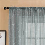 Rideau décoratif gris avec motifs géométriques modernes pour un salon élégant. Ajoute une touche de sophistication à votre intérieur tout en filtrant légèrement la lumière naturelle. Idéal pour créer une ambiance chaleureuse et contemporaine.