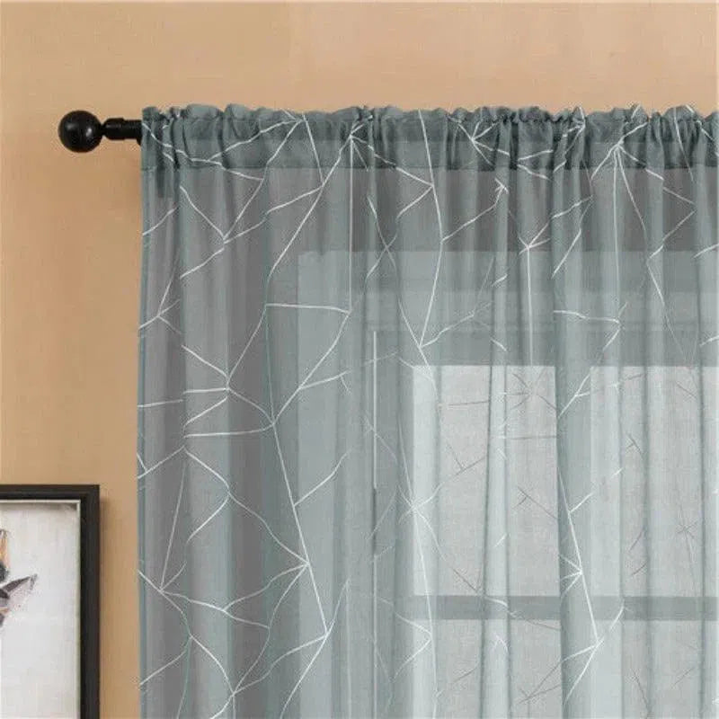 Rideau décoratif gris avec motifs géométriques modernes pour un salon élégant. Ajoute une touche de sophistication à votre intérieur tout en filtrant légèrement la lumière naturelle. Idéal pour créer une ambiance chaleureuse et contemporaine.