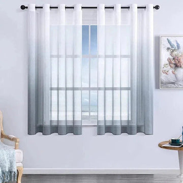 Rideau dégradé blanc et gris sur une fenêtre, parfait pour un salon contemporain, ajoutant une touche élégante et moderne à votre décoration intérieure. Idéal pour filtrer la lumière tout en conservant une ambiance lumineuse et apaisante. Installation facile avec des œillets sur une tringle noire. Parfait pour une ambiance chic et minimaliste.