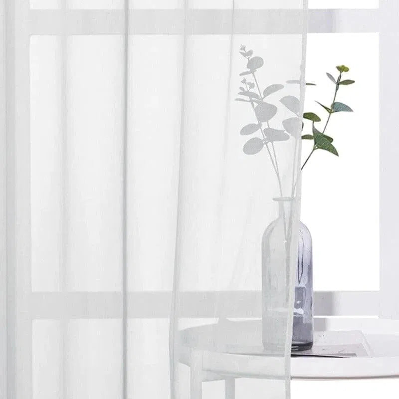 Voilage blanc élégant pour décoration intérieure, idéal pour apporter une touche de légèreté à votre salon. Ce rideau lumineux crée une ambiance apaisante et permet d'adoucir la lumière naturelle sans occulter la vue extérieure. Accessoire parfait pour un intérieur moderne et raffiné.
