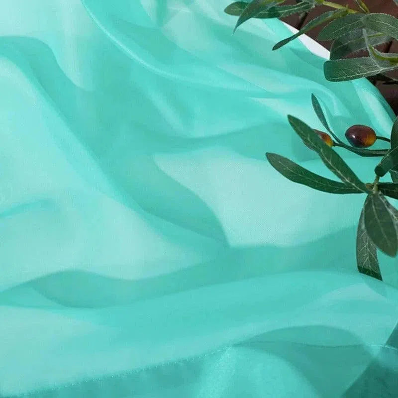 Drapé élégant de couleur turquoise avec feuillage décoratif, idéal pour la décoration intérieure, l'aménagement d'événements ou la fabrication de vêtements tendance. Parfait pour ajouter une touche de fraîcheur et de modernité à tout espace.