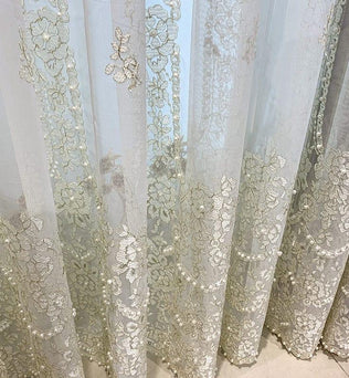 Voilage brodé floral raffiné pour une décoration intérieure élégante. Rideau transparent avec motifs floraux délicats, parfait pour filtrer la lumière tout en ajoutant une touche de sophistication à votre espace de vie. Idéal pour les salons, chambres ou salles à manger. Créez une ambiance lumineuse et chaleureuse avec ce rideau orné.