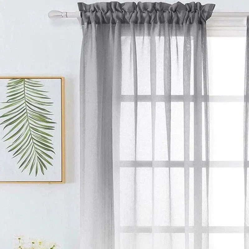 Voilage gris élégant pour salon moderne, filtre la lumière tout en préservant l'intimité, parfait pour une décoration intérieure contemporaine. Découvrez un style raffiné avec ce rideau transparent chic. Ajoutez une touche esthétique à votre espace de vie avec cette tenture moderne.