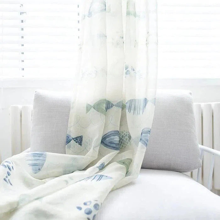Rideau blanc avec motif de poissons bleus, idéal pour une décoration marine. Parfait pour ajouter une touche fraîche et apaisante dans un salon ou une chambre. Ce rideau lumineux s'intègre harmonieusement dans un intérieur moderne et épuré, apportant douceur et ambiance sereine. Idéal pour filtrer la lumière tout en préservant l'intimité.