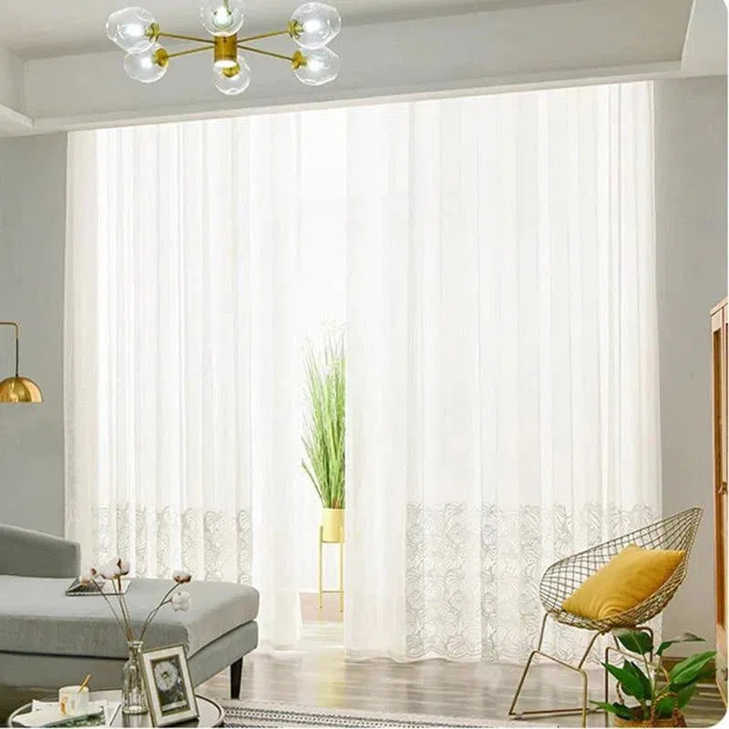 Rideaux blancs élégants apportant une touche lumineuse et sophistiquée à un salon moderne. Rehausse l'ambiance avec des motifs subtils, complété par un canapé gris, une chaise avec coussin jaune et une plante verte pour un décor harmonieux. Idéal pour embellir et illuminer votre intérieur.