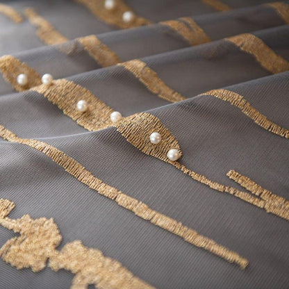 Tissu décoratif élégant avec motifs dorés et perles, idéal pour la décoration intérieure. Ce drapé raffiné apporte une touche de luxe et de sophistication à tout espace. Les détails dorés ajoutent un effet visuel attrayant, parfait pour créer une atmosphère chic dans un salon ou une chambre.