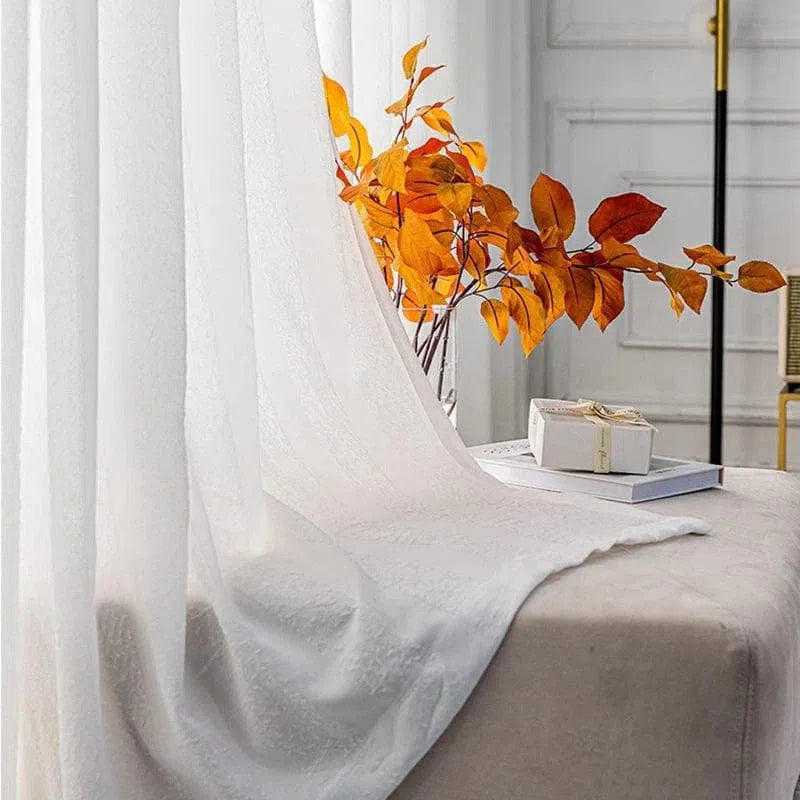 Voilage élégant blanc apportant une touche lumineuse et raffinée à une pièce, idéal pour filtrer la lumière tout en préservant l'intimité. Décoration intérieure accentuée par des feuilles automnales oranges, créant une ambiance chaleureuse. Convient parfaitement au salon ou à la chambre pour un style moderne et chic. Accessoire incontournable pour compléter votre décoration intérieure avec une touche naturelle.