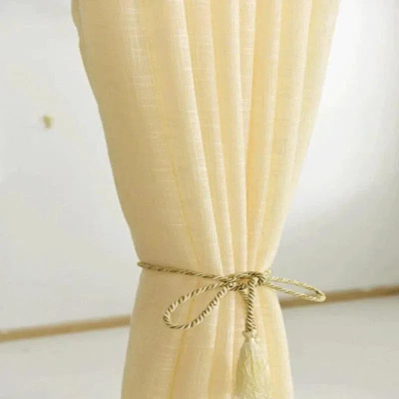 Rideau élégant de couleur beige pour salon, attaché avec un joli cordon décoratif, idéal pour ajouter une touche chaleureuse et raffinée à votre intérieur. Solution parfaite pour contrôler la luminosité et embellir vos espaces de vie.