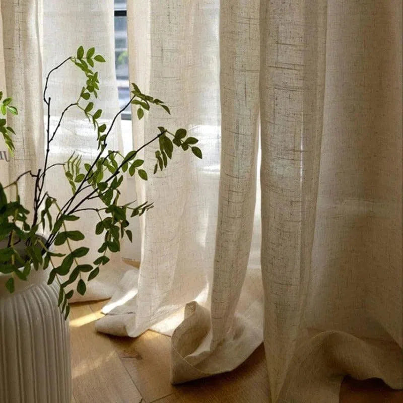 Rideaux élégants filtrant la lumière du jour dans une pièce lumineuse, accentuant un intérieur moderne et apaisant. Un vase avec plante verte ajoute une touche naturelle et rafraîchissante, idéal pour une ambiance chaleureuse et accueillante.