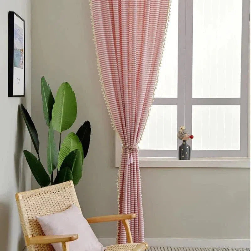 Rideau élégant à rayures roses dans un salon moderne avec une chaise confortable en osier, une plante d'intérieur verte, et une fenêtre lumineuse. Idéal pour ajouter une touche de sophistication et de couleur à votre espace. Accessoire décoratif parfait pour le confort et l'esthétique de votre maison.
