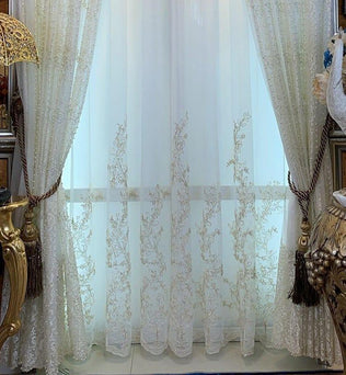 Rideaux élégants et raffinés ornés de motifs floraux délicats, idéaux pour ajouter une touche sophistiquée à votre intérieur. Les embrasses chic et les détails dorés renforcent le charme classique, complétant parfaitement une décoration luxueuse. Parfait pour les salons ou les espaces nécessitant un accent de style et d'élégance.