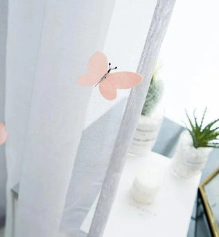 Rideaux blancs décorés de papillons roses pour une ambiance légère et élégante, idéaux pour ajouter une touche de fraîcheur printanière à votre intérieur moderne. Parfaits pour le salon ou la chambre, ces rideaux transforment subtilement la lumière du jour tout en créant une atmosphère apaisante et naturelle.